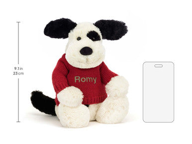 Chiot timide noir et crème avec pull rouge personnalisé